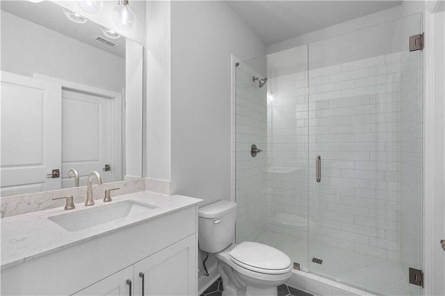 Bathroom featuring a shower stall and vanity Bathroom featuring a shower stall and vanity