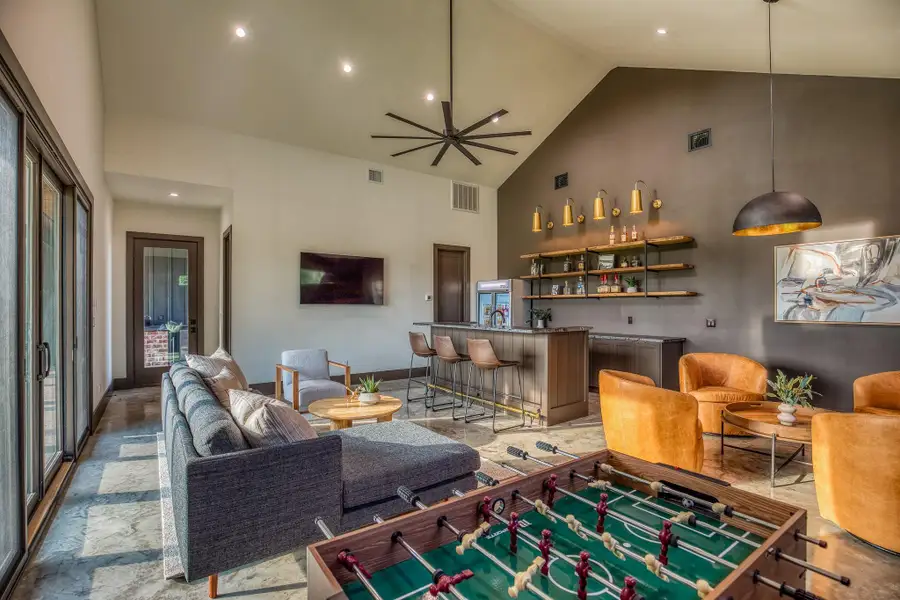 Living room featuring high vaulted ceiling, a bar, and recessed lighting Living room featuring high vaulted ceiling, a bar, and recessed lighting