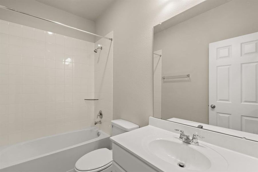 The secondary bath features tile flooring, white cabinetry and light countertops and a shower/tub combo. Perfect for accommodating any visiting family and friends.