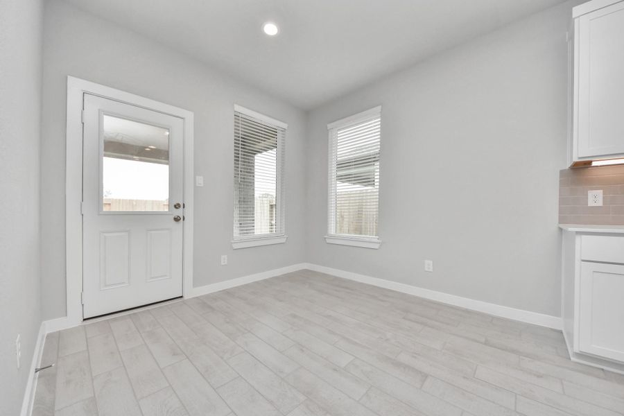 Enjoy breakfast with ease in the connected and cozy breakfast area, seamlessly integrated with the kitchen for utmost convenience. Step through the back door for a breath of fresh air onto the covered patio, extending your living space to the outdoors. Sample photo of completed home with similar floor plan. Actual colors and selections may vary.