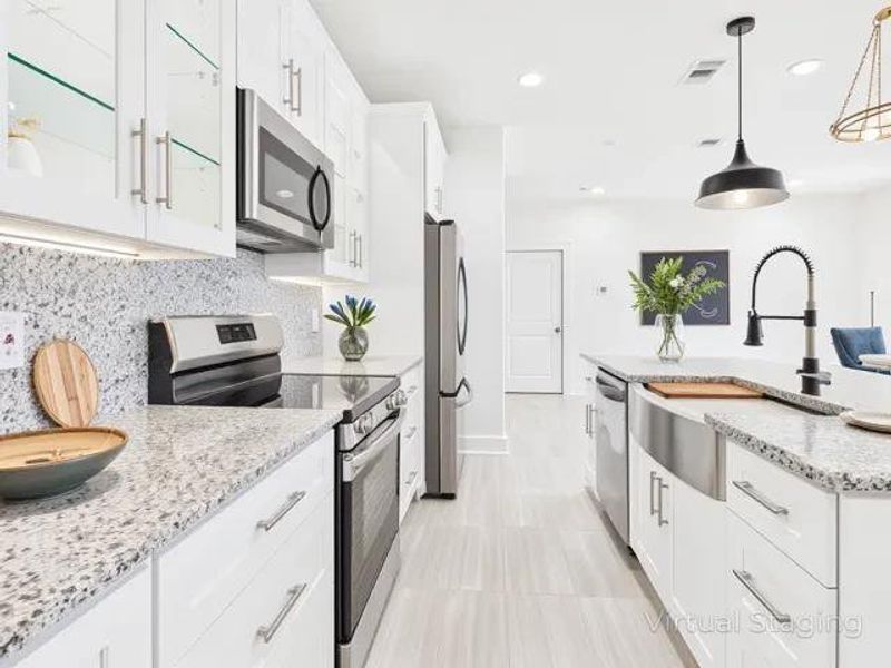 Kitchen featuring appliances with stainless steel finishes, white cabinets, light stone countertops, pendant lighting, and tasteful backsplash Kitchen featuring appliances with stainless steel finishes, white cabinets, light stone countertops, pendant lighting, and tasteful backsplash