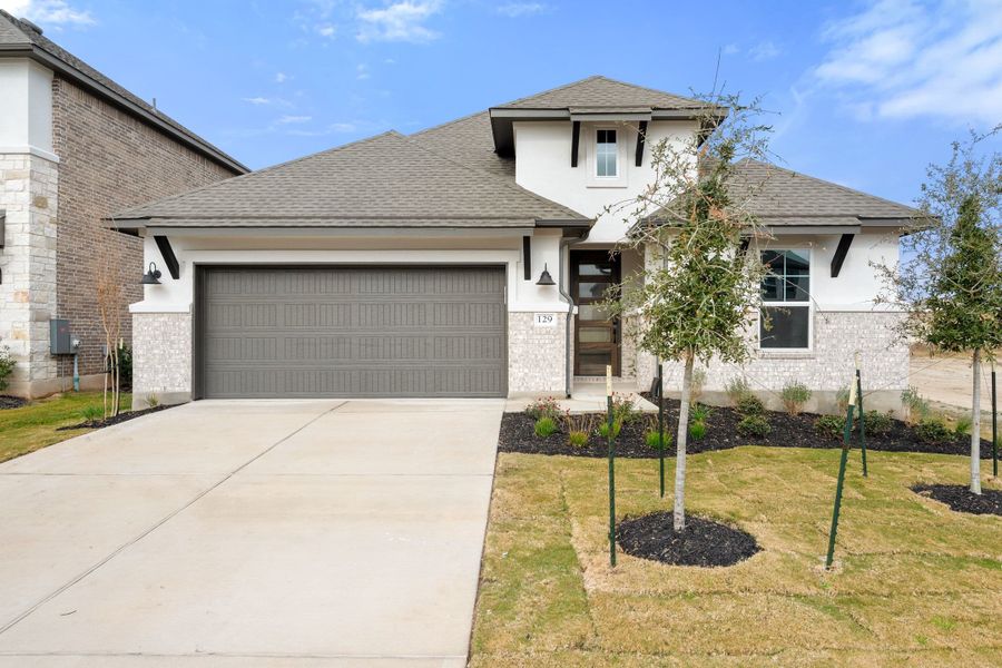 Front exterior of a new home in Lariat, Liberty Hill, TX, highlighting curb appeal (Image 1). Front exterior of a new home in Lariat, Liberty Hill, TX, highlighting curb appeal (Image 1).