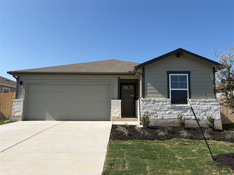 Ranch-style house featuring concrete driveway, an attached garage, and stone siding