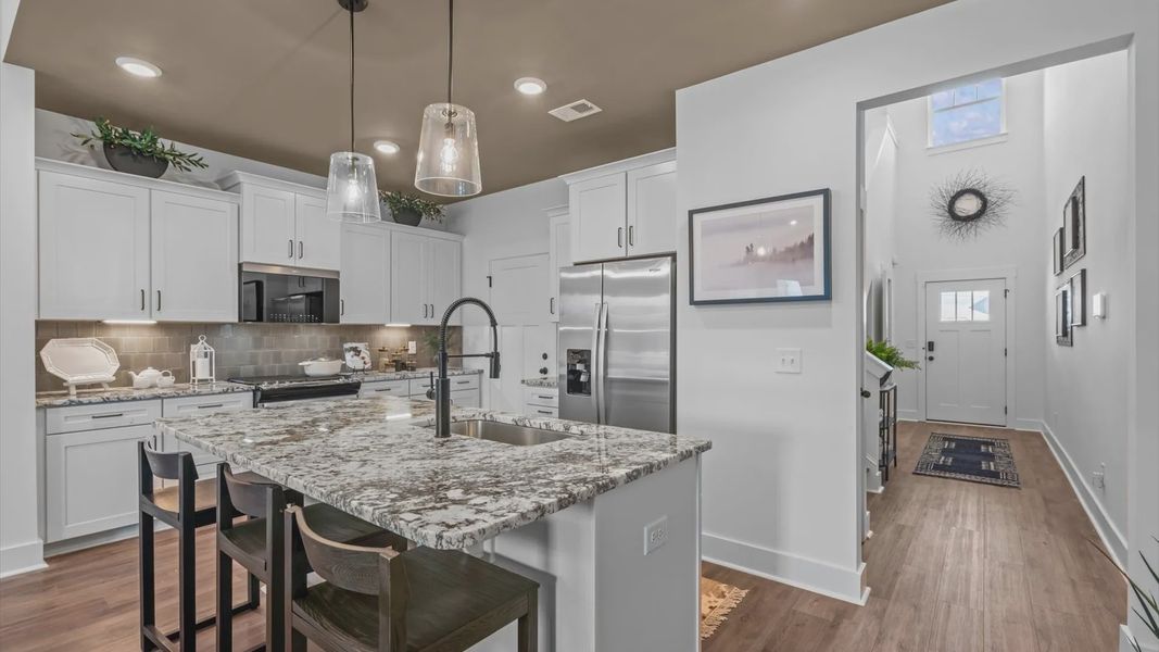 Elegant kitchen with large island and pendant lighting in this first-class DRB Homes design