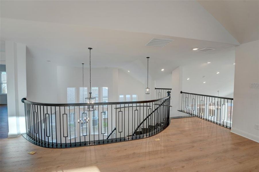 Hall with a chandelier, visible vents, an upstairs landing, and vinyl  inished floors