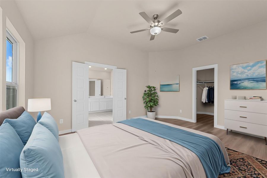 A tranquil bedroom features vaulted ceilings and light wood-look flooring, offering an inviting private retreat.