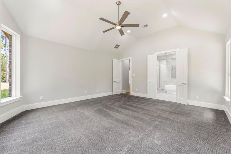 Generous proportions and a vaulted ceiling create space for a substantial bedroom suite and a comfortable sitting area.