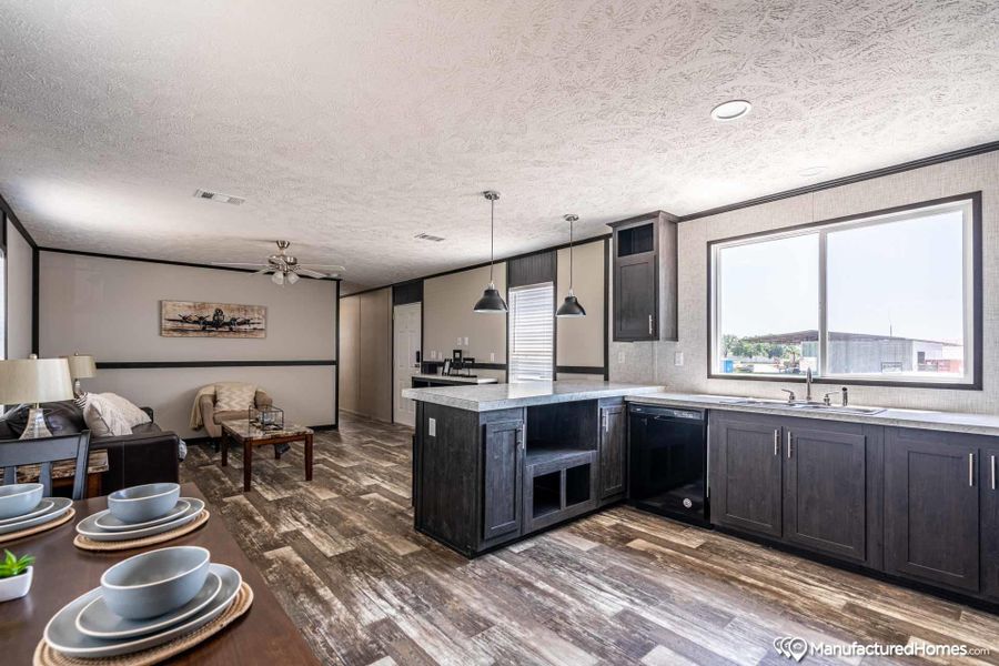 An open concept living and kitchen area features rich wood flooring and abundant natural light.