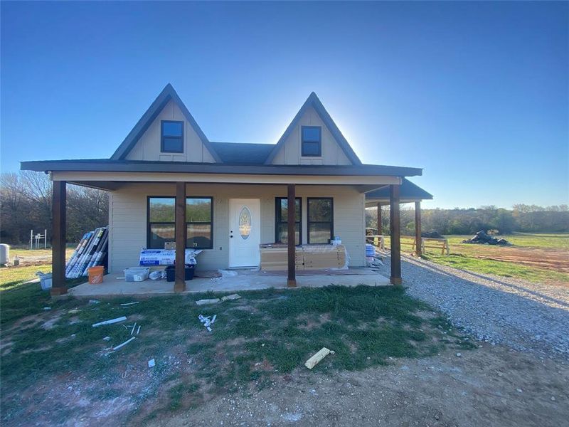 View of front of house featuring covered porch and a front yard