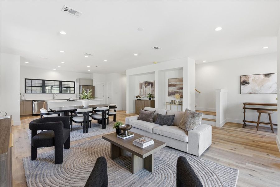 Modern open-concept living area with a seamless flow between the kitchen, dining, and living spaces.