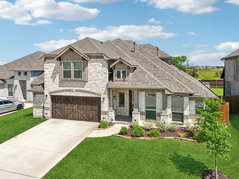 French provincial home featuring stone siding, an attached garage, a shingled roof, and concrete driveway French provincial home featuring stone siding, an attached garage, a shingled roof, and concrete driveway