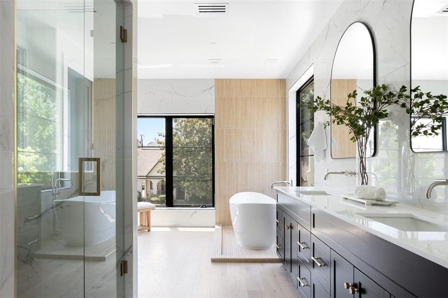 Bathroom with a shower with door, tile walls, and dual bowl vanity