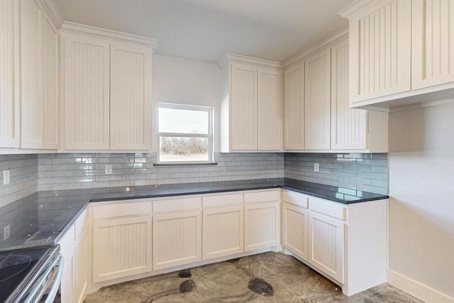 Kitchen featuring baseboards, electric range, and decorative backsplash