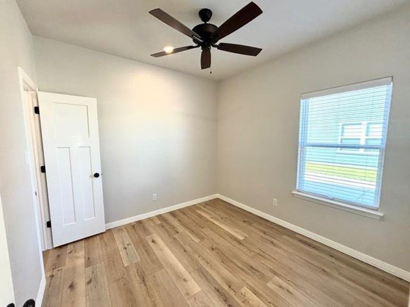 Empty room with ceiling fan and light wood-type flooring