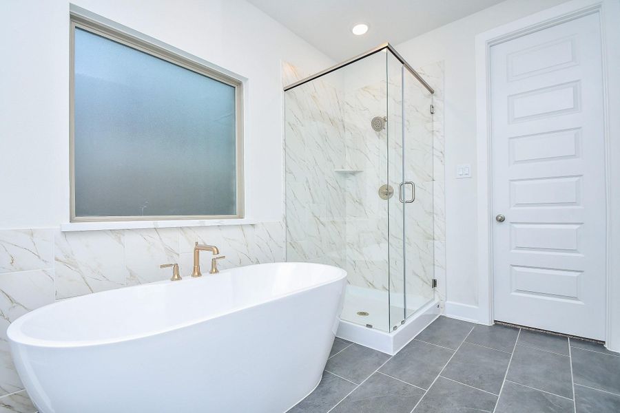 spa-like primary bathroom featuring a soaking tub and a separate walk-in shower.