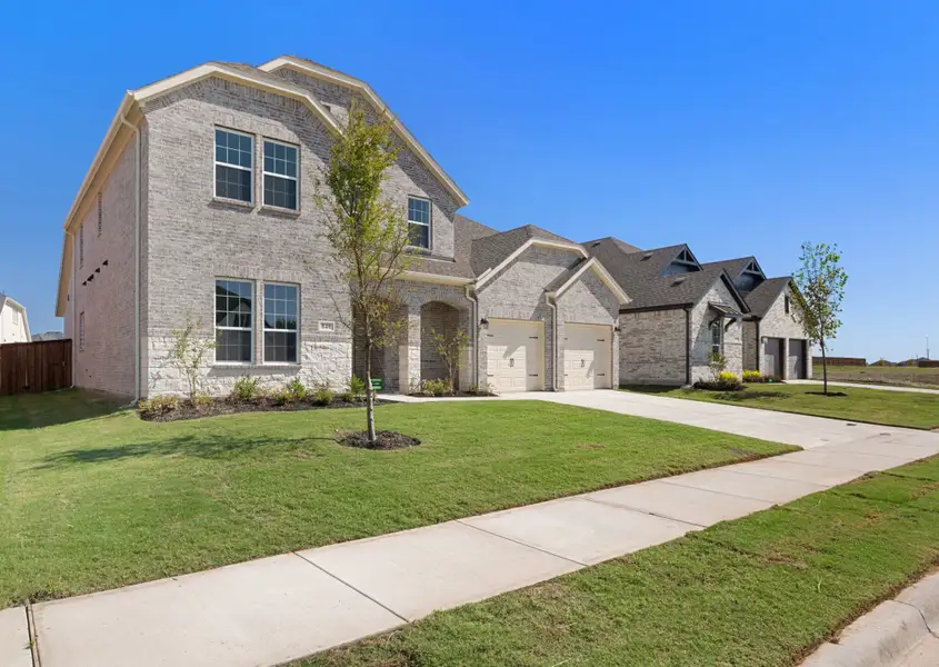 Front exterior of a new home in Lake Breeze, Lavon, TX, highlighting curb appeal (Image 2). Front exterior of a new home in Lake Breeze, Lavon, TX, highlighting curb appeal (Image 2).