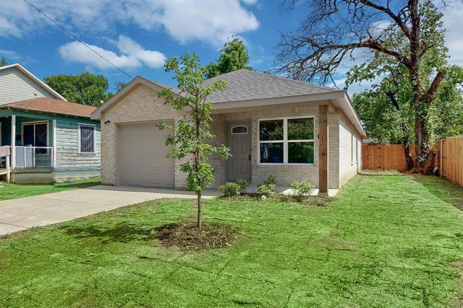 View of front of property with a garage and a front lawn