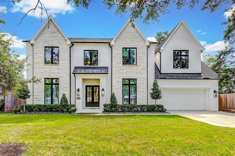 This elegant two-story home features a stone facade and large windows, offering a modern, inviting look. The well-maintained front lawn and spacious driveway lead to an attached garage. Ideal for buyers seeking luxury and curb appeal.