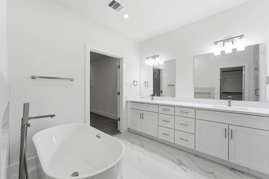 Dual vanities provide generous counter space and storage in the primary bath.
