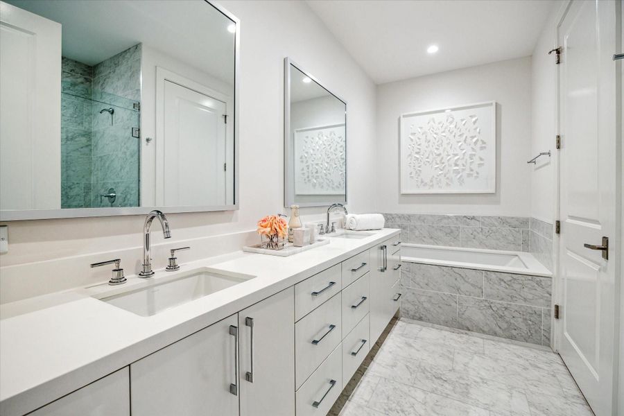 Primary bathroom with dual sinks, soaking tub, glass-framed walk-in shower with seat, private water closet, linen closet and a large walk-in dressing area Primary bathroom with dual sinks, soaking tub, glass-framed walk-in shower with seat, private water closet, linen closet and a large walk-in dressing area