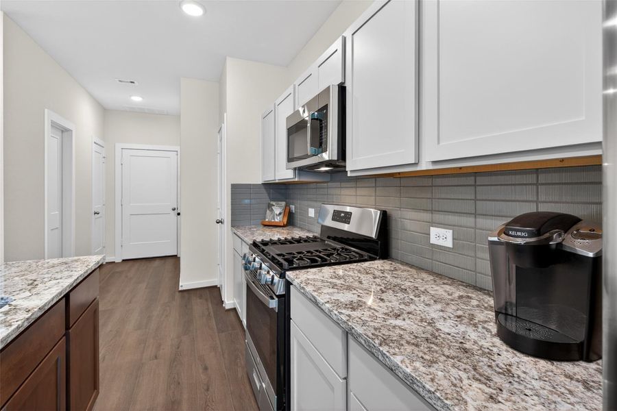 Gas range with a modern tile backsplash and generous counter space, ideal for everyday cooking and entertaining. Gas range with a modern tile backsplash and generous counter space, ideal for everyday cooking and entertaining.