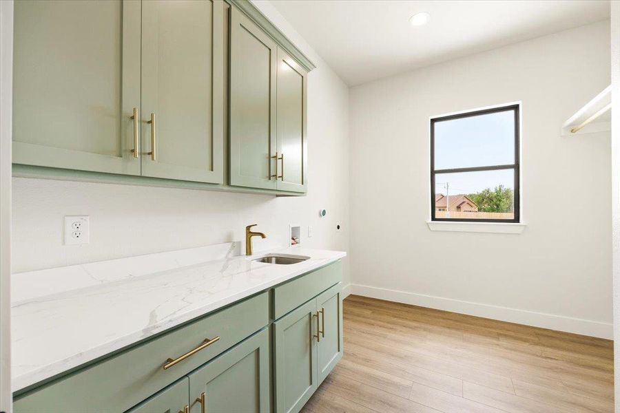 Ample storage and a practical sink define this dedicated laundry area.