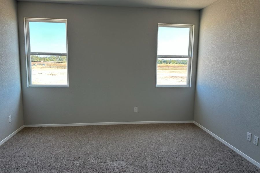 Image of home primary with two windows on a white wall and light carpet