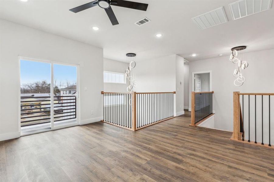 Unfurnished room featuring dark hardwood / wood-style flooring and ceiling fan with notable chandelier