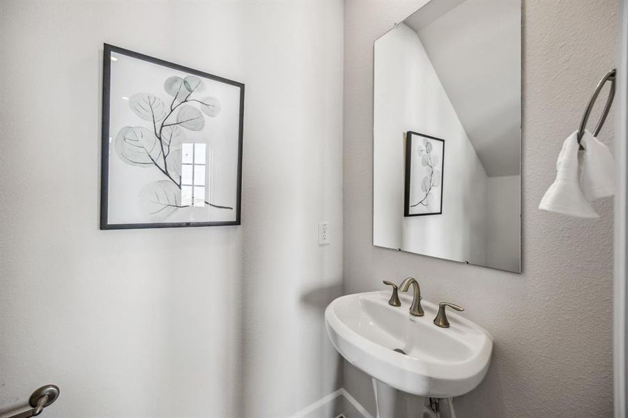 A discrete powder room is tucked under the stairs.