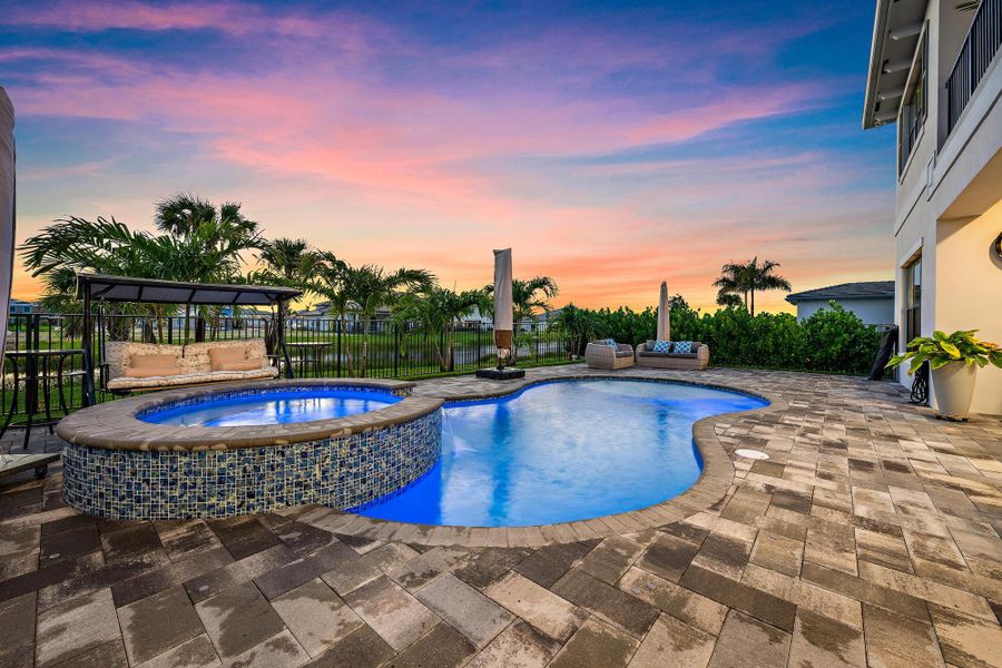 Extended pool deck, spa, and waterfall feature.