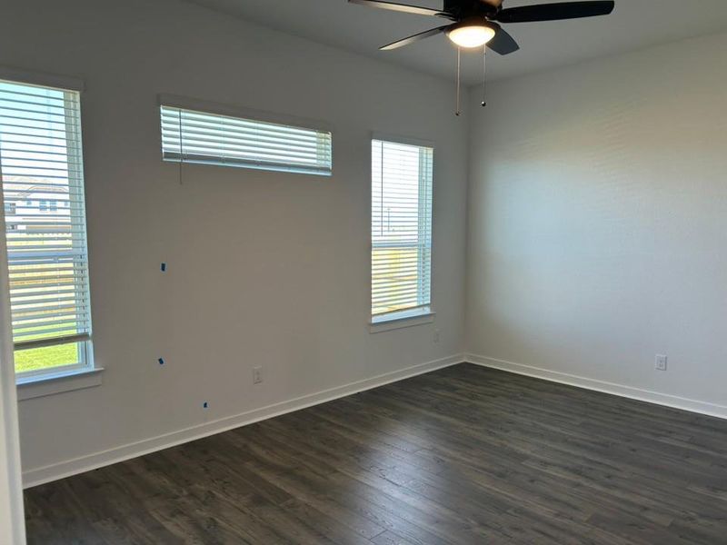 Empty room featuring dark wood-type flooring and ceiling fan Empty room featuring dark wood-type flooring and ceiling fan