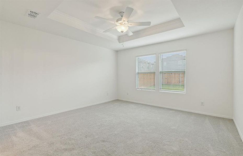 Elegant owner's suite with tray ceiling *real home pictured