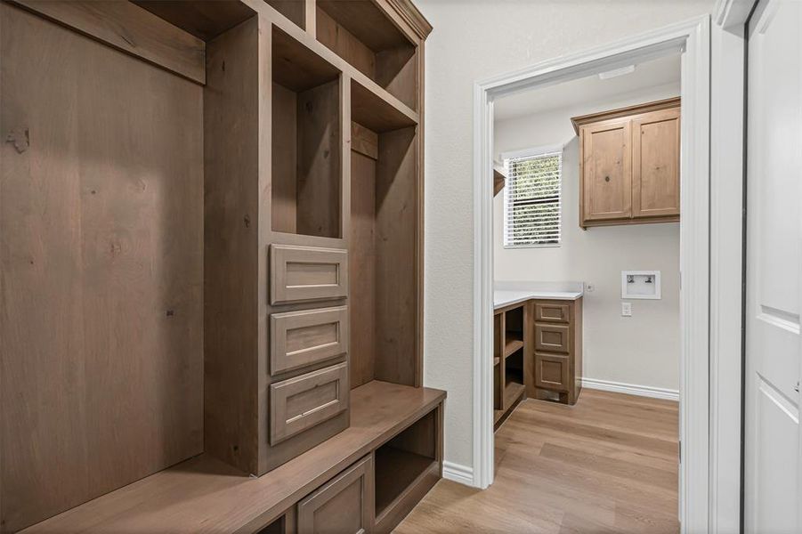Mudroom with light wood-type flooring and baseboards