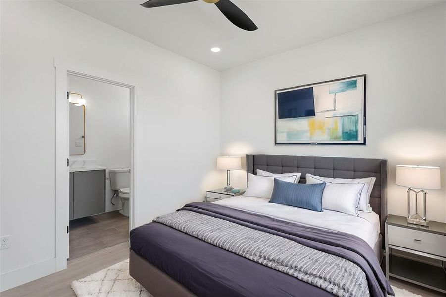 Virtually Staged: This secondary bedroom located on the first floor features recessed lighting, a ceiling fan, and vinyl plank floors.