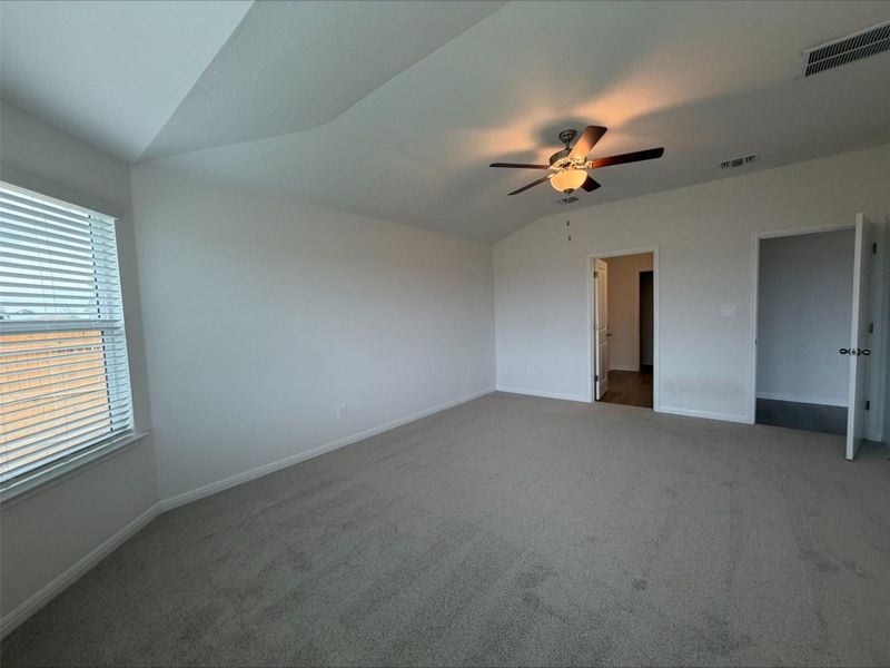 Unfurnished bedroom with lofted ceiling, carpet, and a ceiling fan