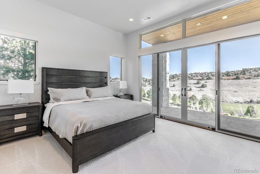 Two of the lower level bedrooms enjoy direct access to the outdoor patio, blending privacy with connection to the landscape.