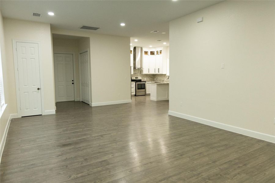 Unfurnished living room featuring recessed lighting and dark wood-style floors