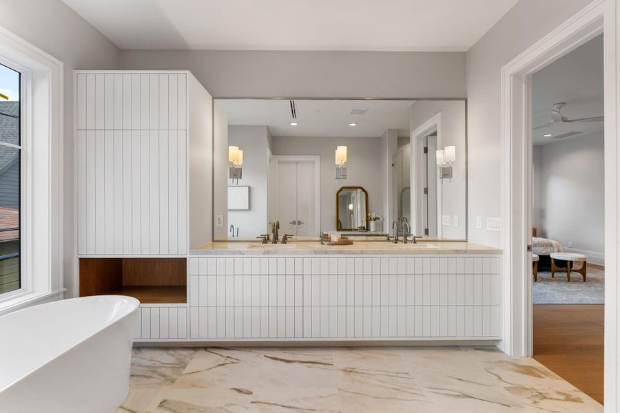 Primary bathroom with abundance of cabinetry and large soaking tub.
