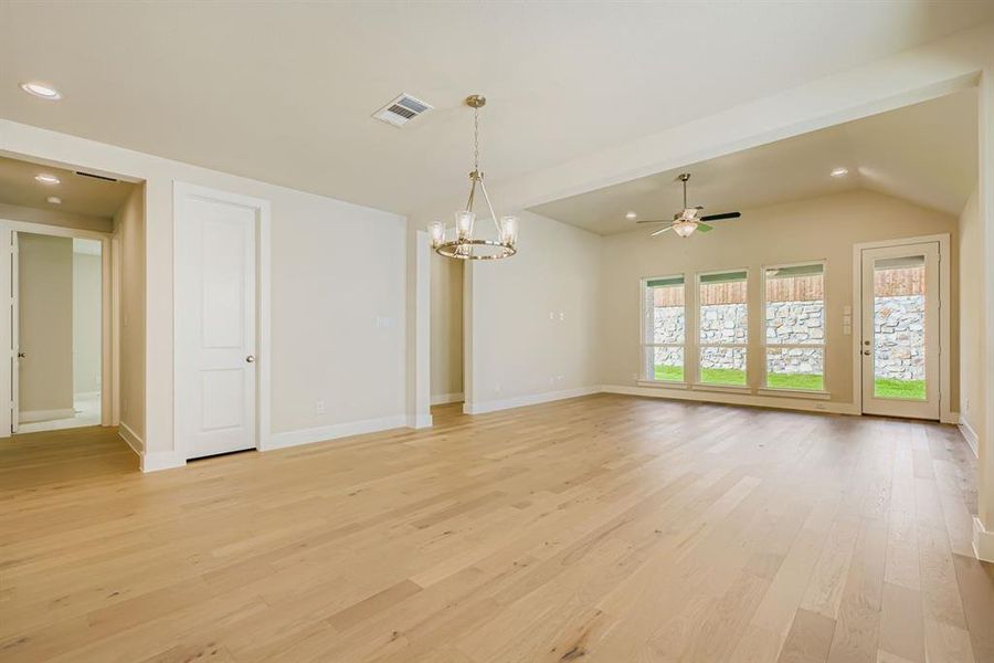 Unfurnished room with recessed lighting, light wood finished floors, a ceiling fan, a chandelier, and lofted ceiling