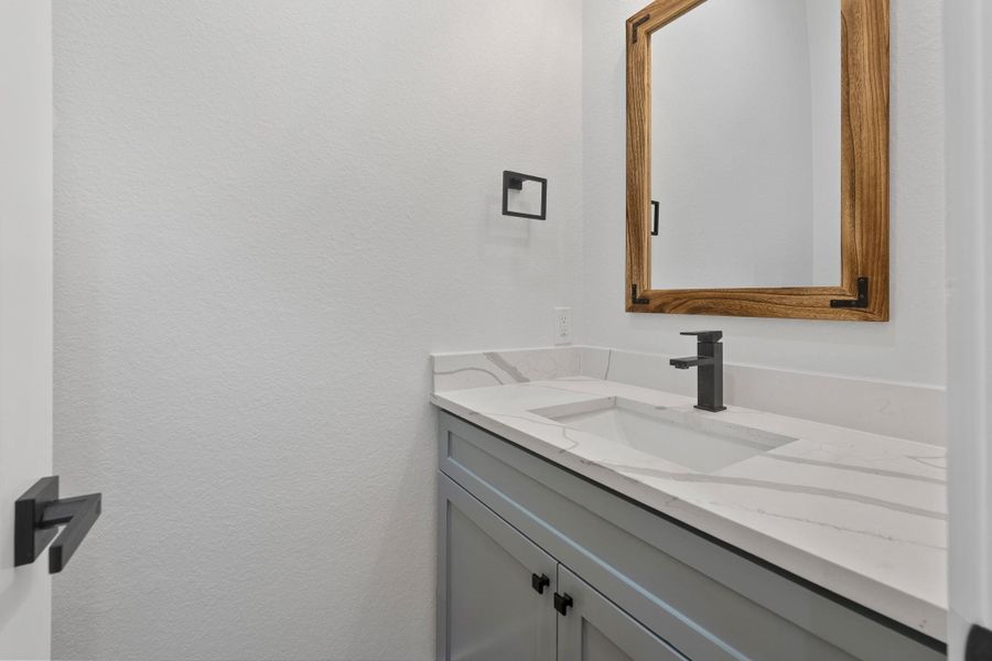 Elegant downstairs guest bath with custom cabinets and quartz countertops. Elegant downstairs guest bath with custom cabinets and quartz countertops.