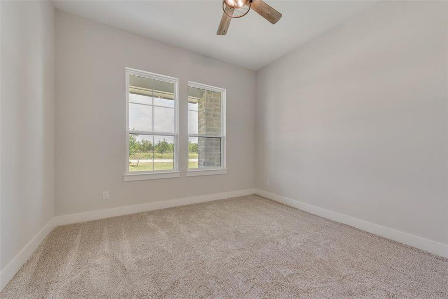 Carpeted empty room with ceiling fan