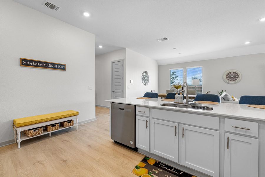 Kitchen with white cabinets, light wood finished floors, light stone countertops, dishwasher, and recessed lighting Kitchen with white cabinets, light wood finished floors, light stone countertops, dishwasher, and recessed lighting