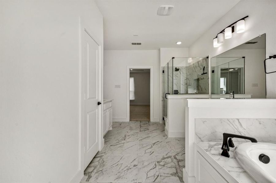 Bathroom featuring vanity and independent shower and bath