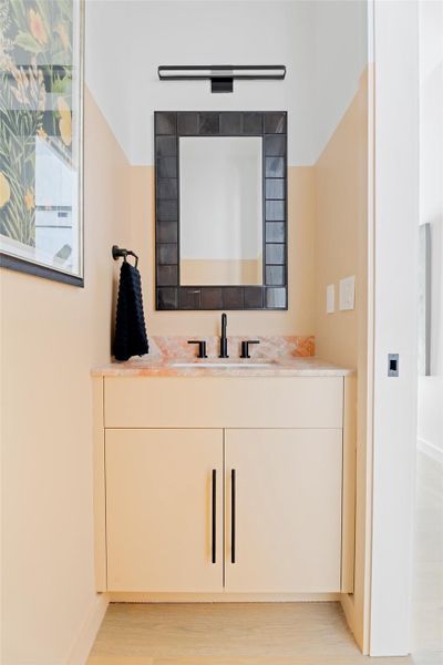 Bathroom featuring vanity, baseboards, and wood finished floors