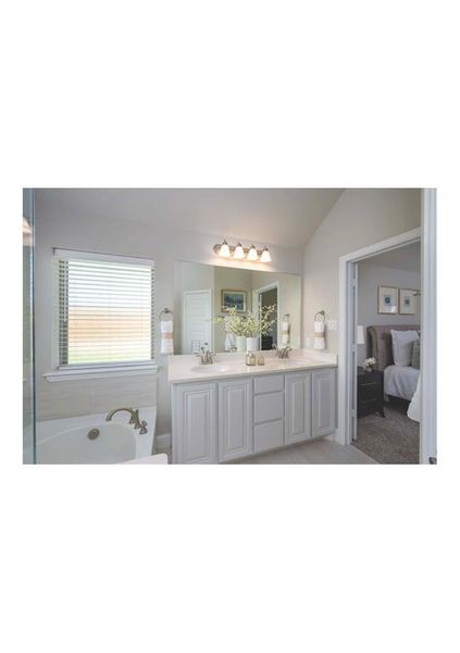 Bathroom featuring a washtub, vanity, and lofted ceiling