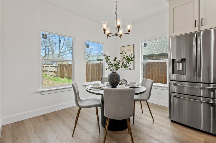 Dining space with an inviting chandelier, light wood-style flooring, and baseboards