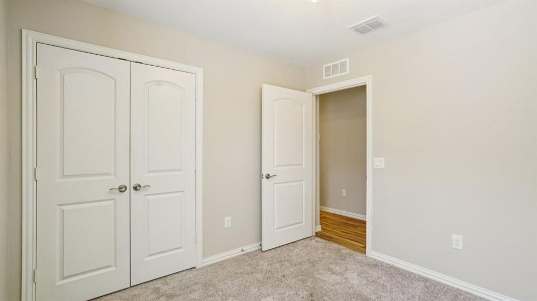 Unfurnished bedroom featuring carpet flooring and a closet Unfurnished bedroom featuring carpet flooring and a closet