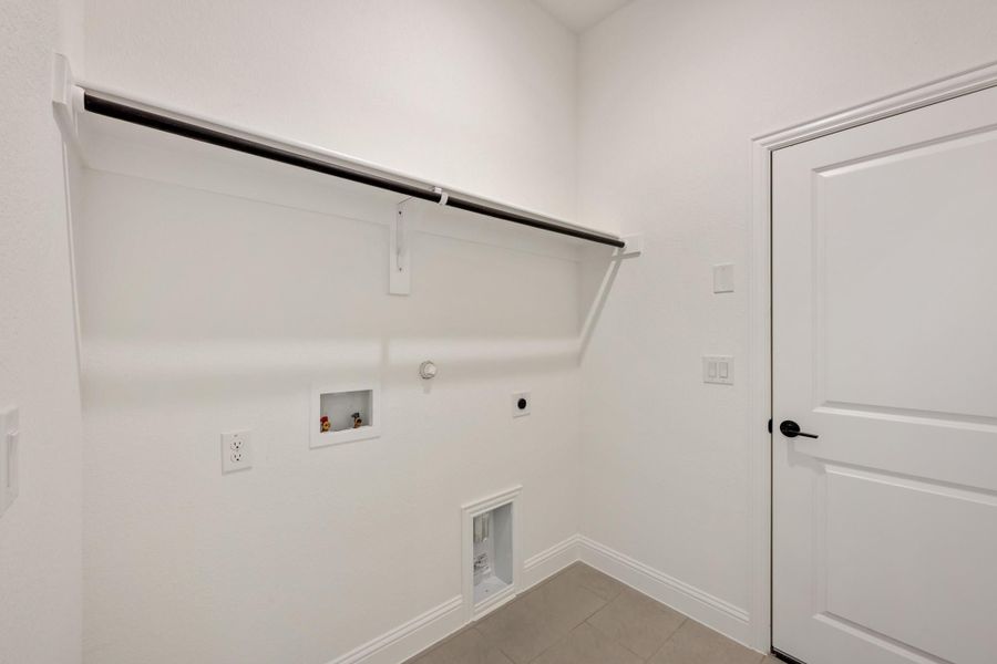 Laundry room with wall-mounted shelf, hanging rod, washer and dryer hookups, and white walls Laundry room with wall-mounted shelf, hanging rod, washer and dryer hookups, and white walls