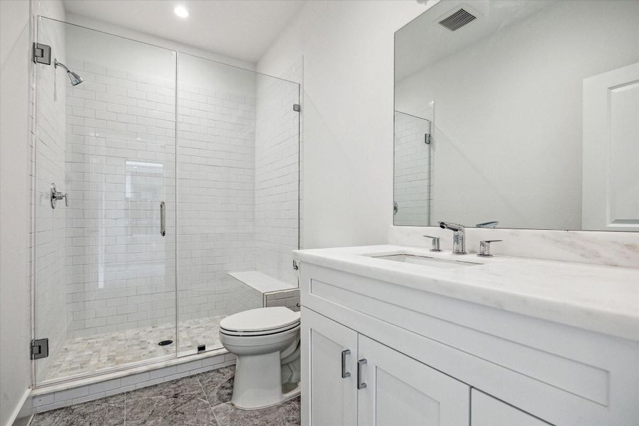 En Suite Bathroom for the 1st Floor's Bedroom * Large Shower with Bench Seating and Subway Tile on the Sides and Marble Floor.
