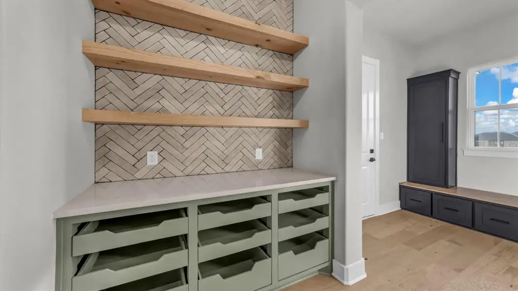 Built-in organizational unit with a light-toned herringbone tile backsplash and three floating wood shelves Built-in organizational unit with a light-toned herringbone tile backsplash and three floating wood shelves